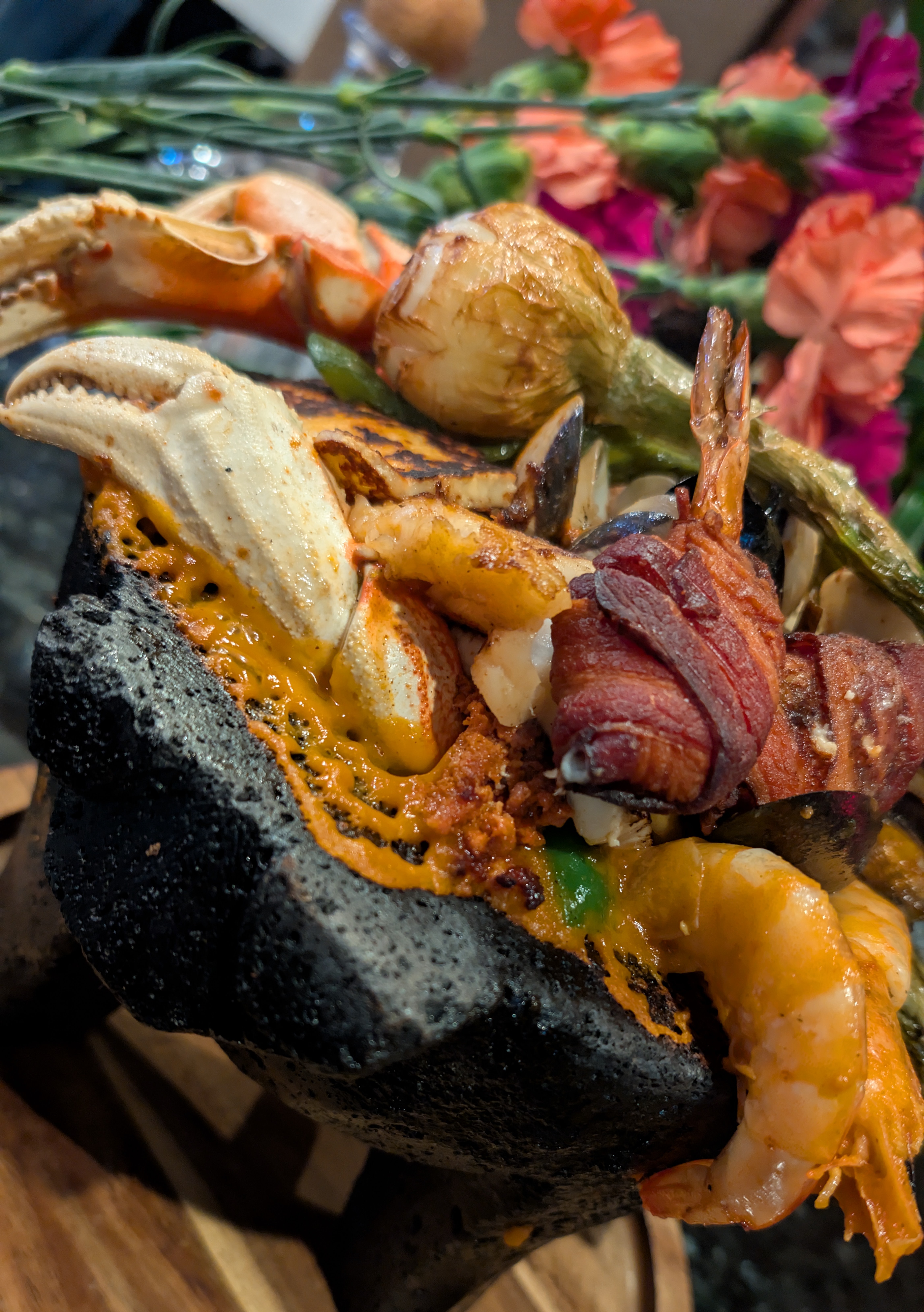 A seafood molcajete with crab, shrimp, peppers, and grilled vegetables.